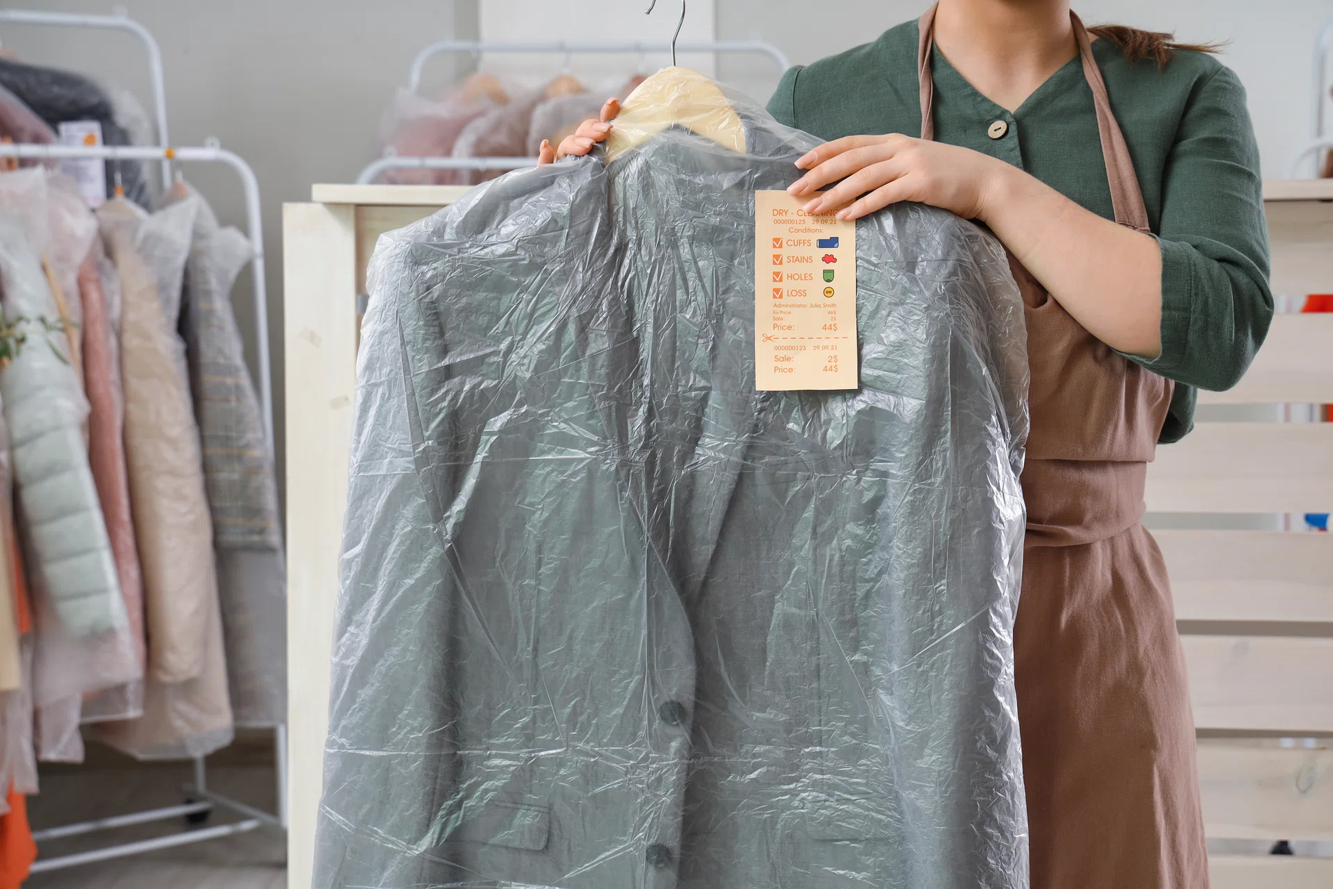 Young female worker with suit at dry-cleaner’s.