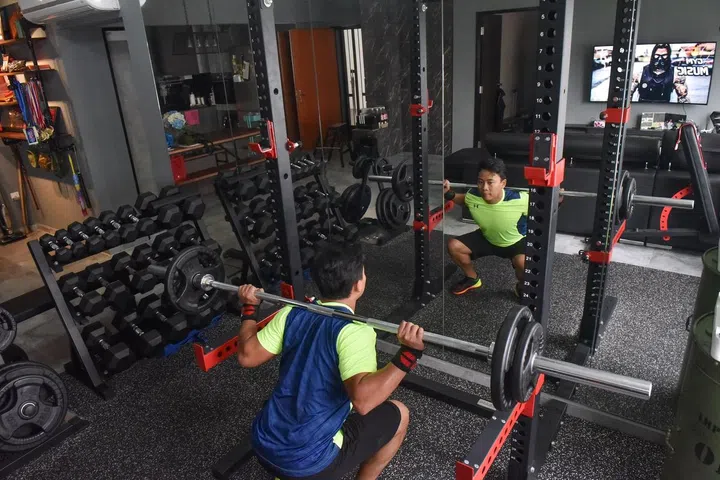 The gym equipment are conveniently located in the living room, behind the sofa and television set.