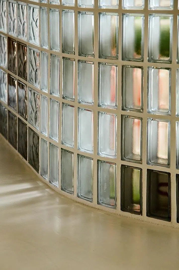 This curved glass block wall departs from the typical straight installation, showcasing the craft involved while echoing Kai’s childhood memories of swimming pool glass block walls built by his father.