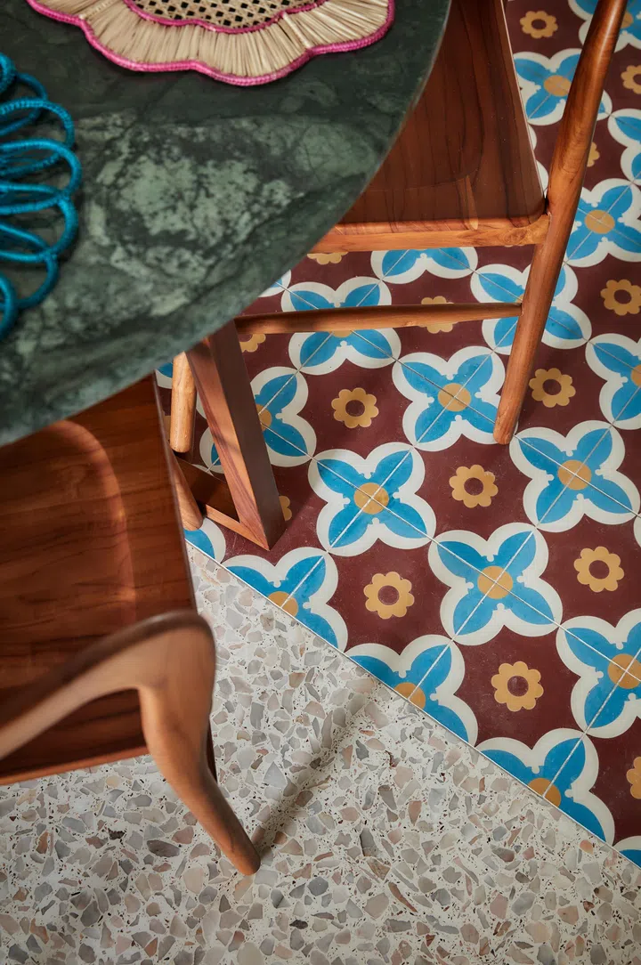 Terrazzo meets patterned tiles at the dining area, where the transition defines the space without enclosing it.