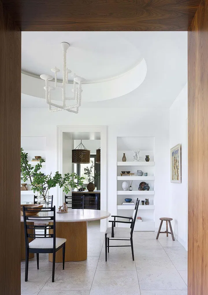 The kitchen has an alcove with shelves displaying the owner’s ceramics collection.