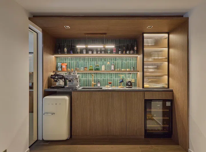Set within a timber-lined alcove, the bar combines coffee, drinks and storage in a compact, integrated zone between living and dining.