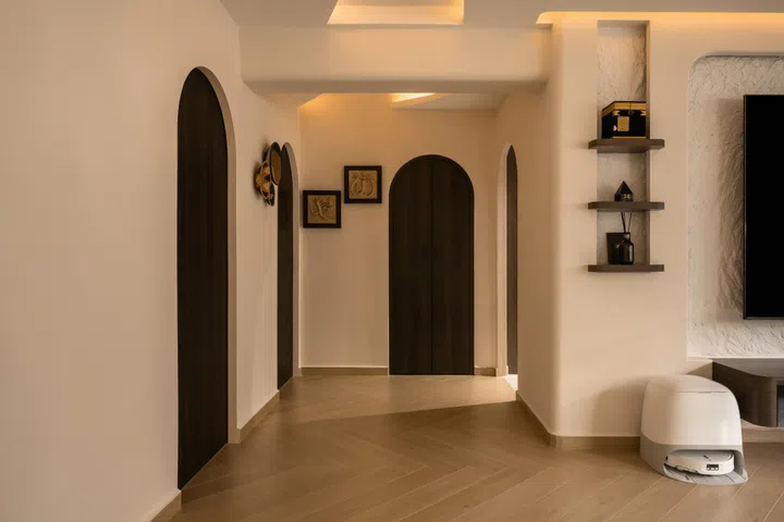 Arched doorways replace conventional rectangular openings, creating a gentle rhythm that carries the home’s signature curves into the private quarters.