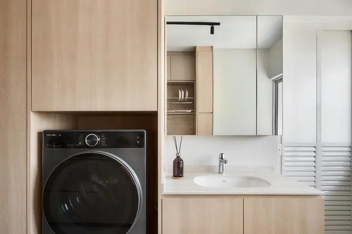 A built-in sink sits next to a niche where the washing machine is neatly tucked into.