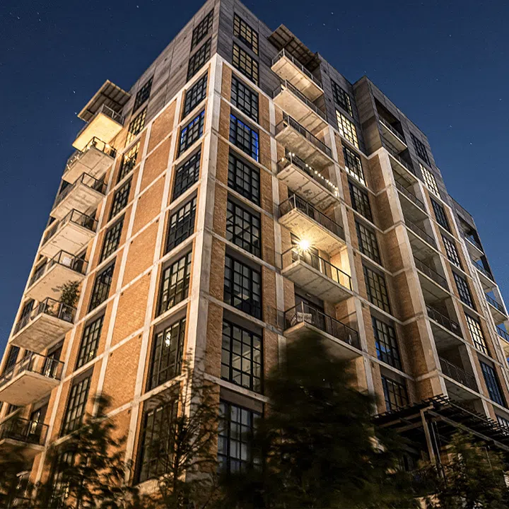 Ground up night view of a lit exterior of an apartment building. Image from Unsplash