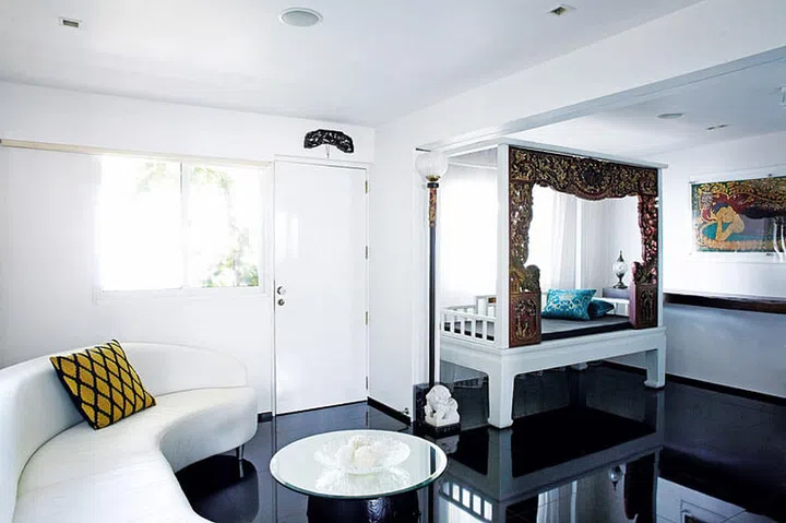 Moving the kitchen to the back room helped create a larger dining area. The reflective black flooring adds to the roomy feel.
