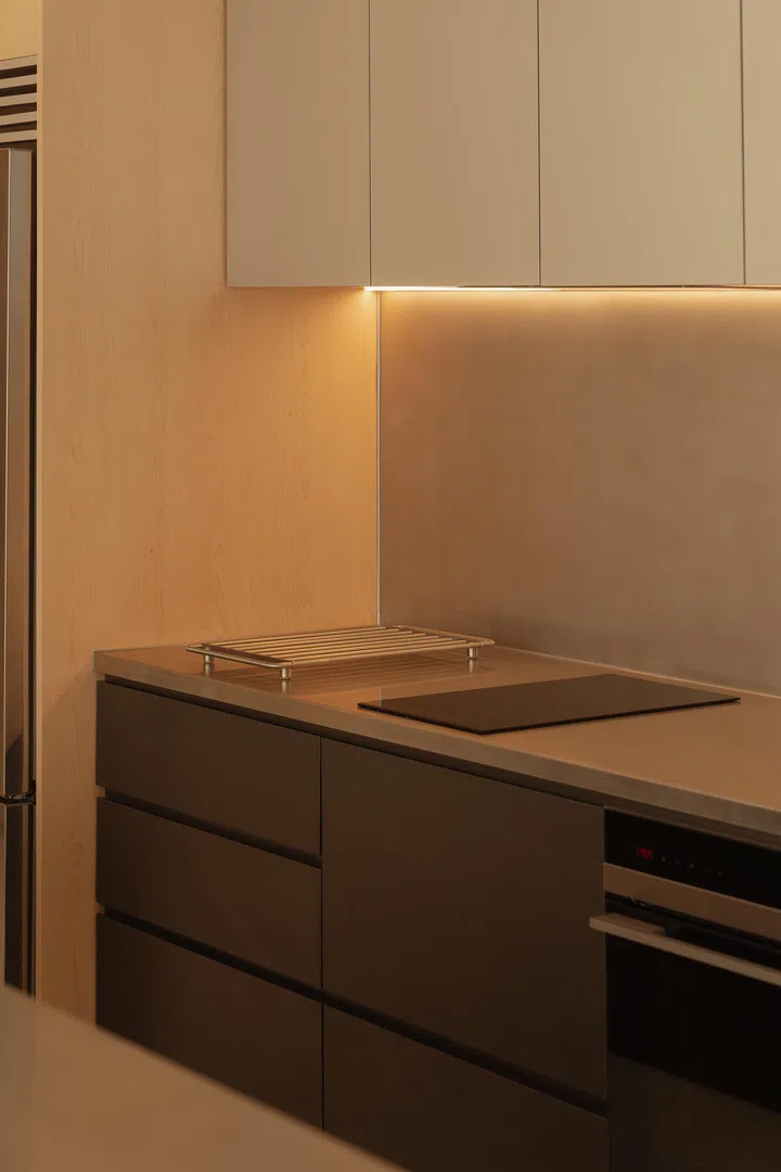 Clean-lined drawers and concealed lighting emphasise precision and calm in the cooking area.