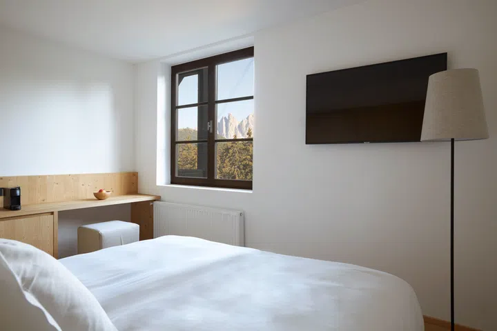 Minimalist interiors of the FORESTIS room features native pine wood, raw stone, and clean glass.
