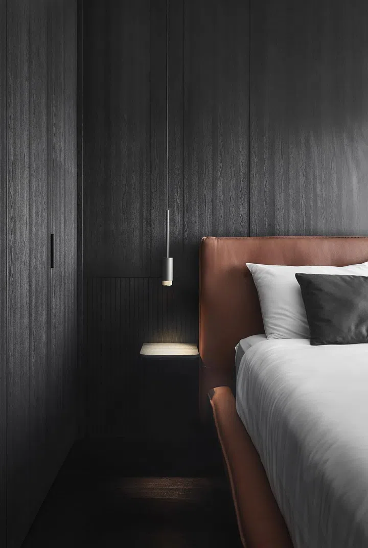 Buster + Punch bedside pendant lamps hang elegantly from the ceiling on either side of the bed in this all-black 4-room Punggol HDB.
