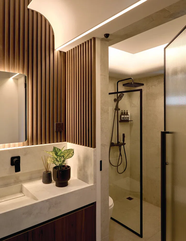Textured stone-look tiles and a wall-hung toilet give this bathroom a refined, resort-like feel. 