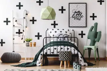 White ladder, grey pouf and cactus pillow on mint chair in kid's bedroom with green accents. Photo 123RF