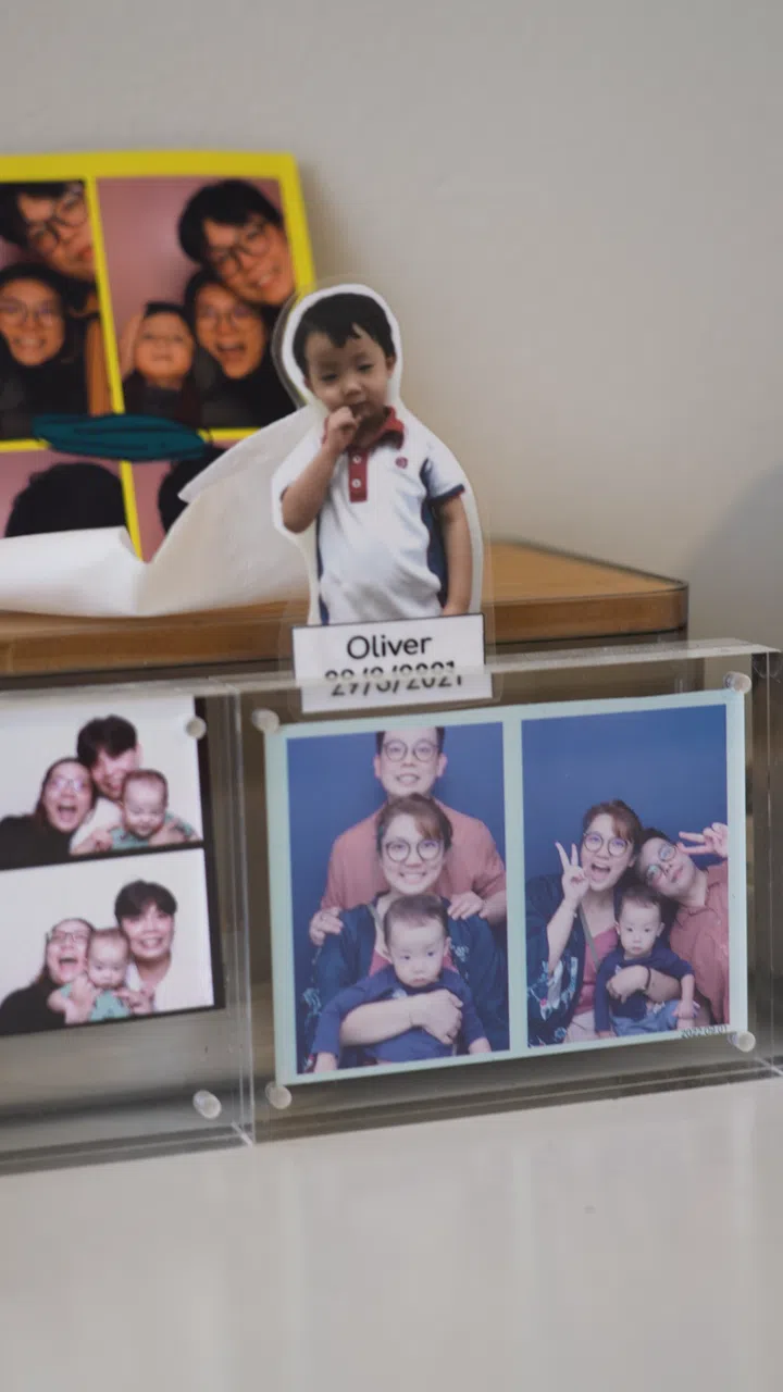 Family photographs in interior designer Cedrick Law and wife Chua Tse Lyn's 4-room HDB resale in Bedok.