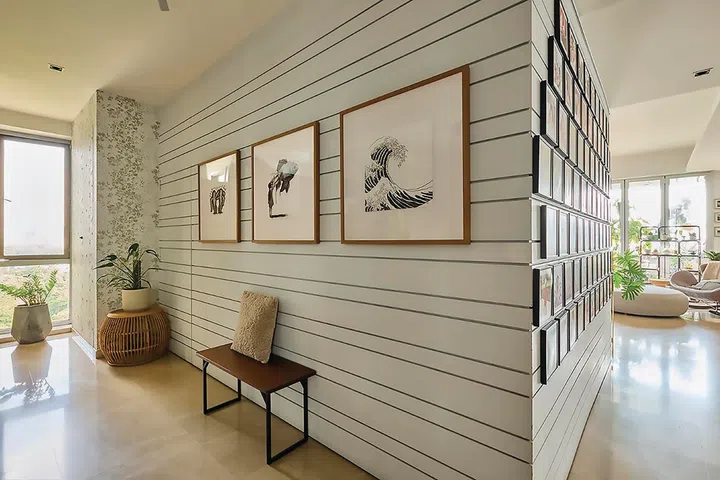Three framed black-and-white prints and a solitary stool in the entrance foyer.