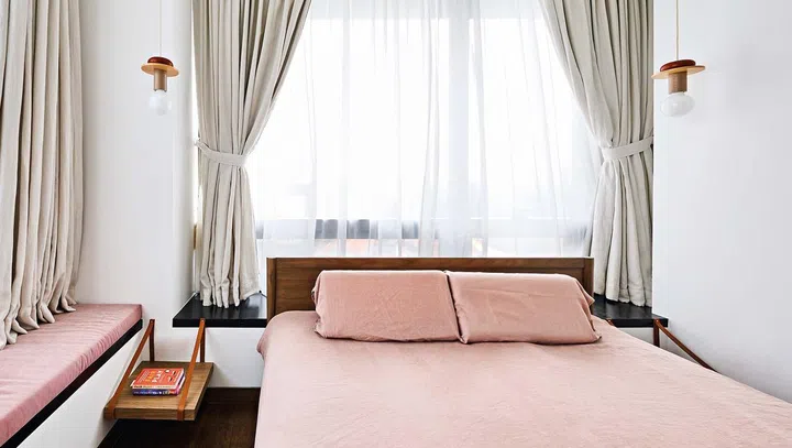 The master bedroom is the couple’s favourite space. A pair of bedside pendant lamps from Schneid Studio draws the eye upward to divert attention away from the limited floor area. Motorised curtains make it possible to operate the curtains behind the headboard.