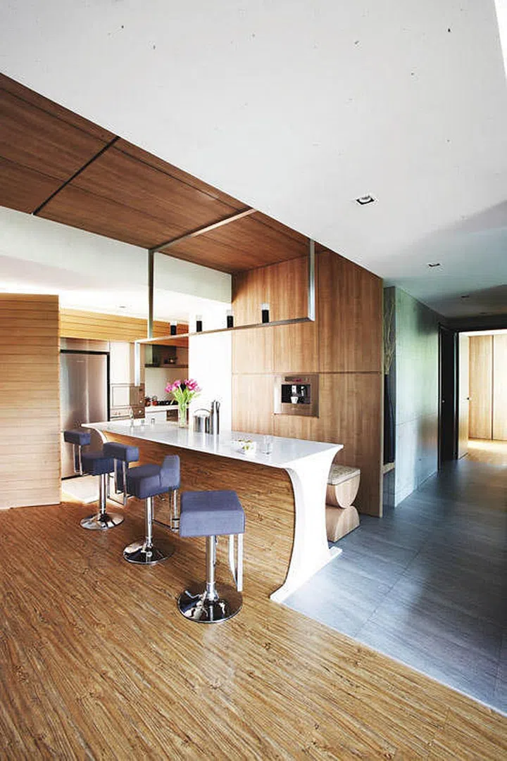 All wood dining room with high bar kitchen island dining table for a couple and their 2 children’s penthouse apartment in Yio Chu Kang.