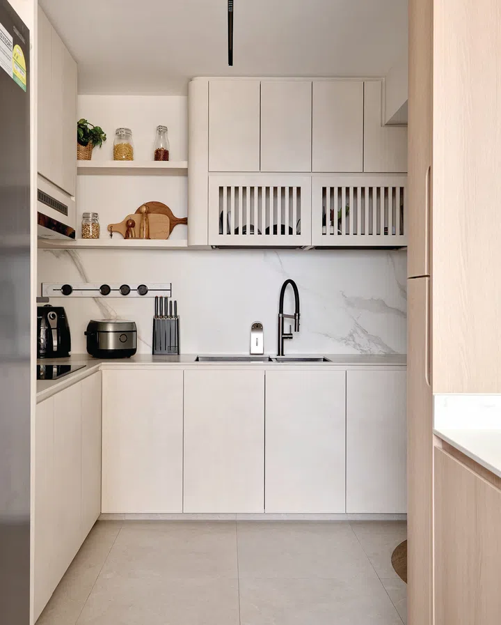 The kitchen counter is streamlined and functional, offering ample prep space while maintaining a clutter-free look.