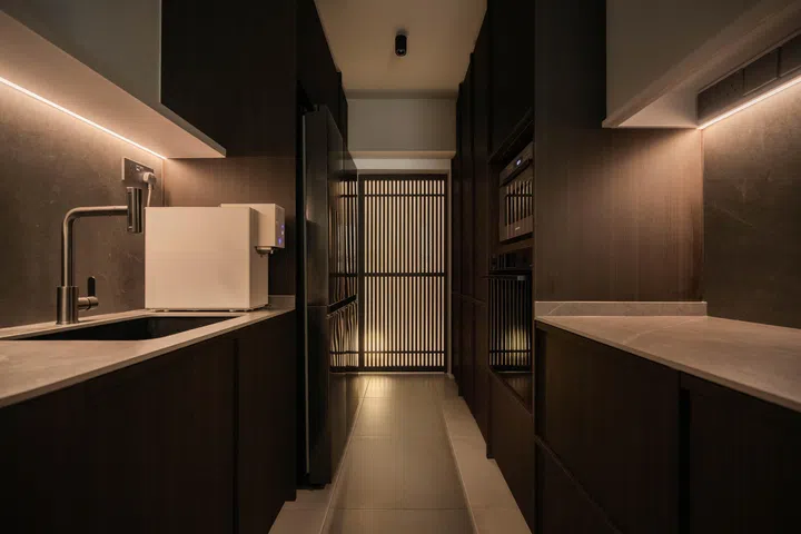  The galley kitchen was designed with a darker palette, as advised by the Feng Shui master, giving it a sleek and dramatic presence.

