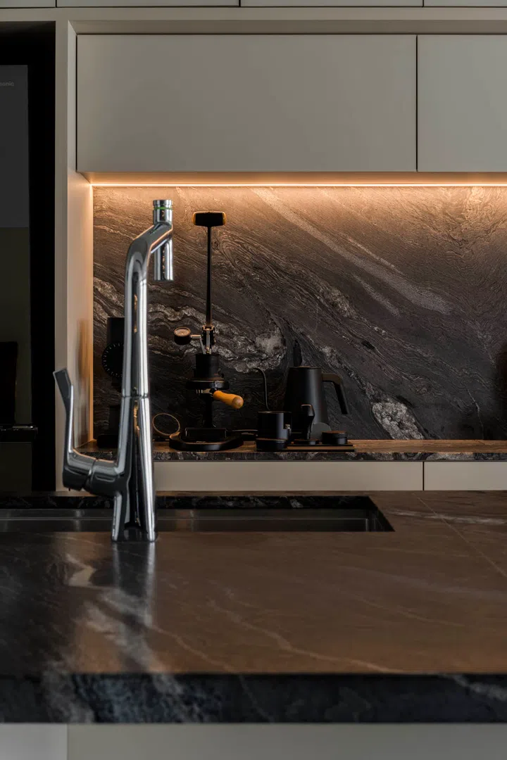 A dedicated pantry wall houses the couple’s coffee and tea setup, aligned seamlessly into the cabinetry.