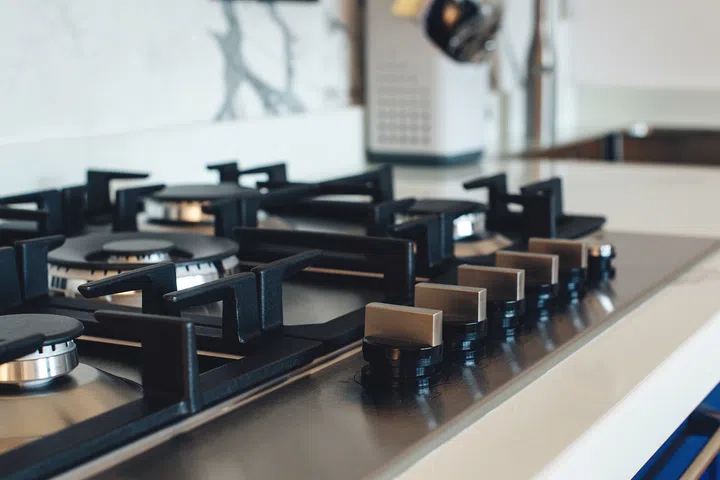 Kitchen gas stove, close up. New gas stove appliance and countertop surface at modern kitchen. Modern kitchen stove cook.