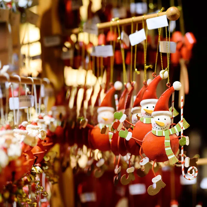 Christmas Snowman sold at traditional Christmas market. Decorated and illuminated shopping stands with variety of Xmas toys. Christmas market in Bavaria, Germany.