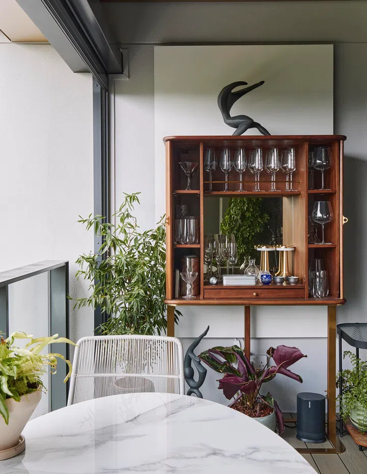 The balcony is anchored by a repurposed cabinet and framed for conversation, wine, and cityscape views.