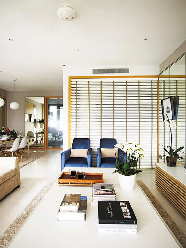 Lounge armchairs in the living room of a 4-bedroom apartment in Oceanfront @ Sentosa Cove condominium with luxurious interior design.