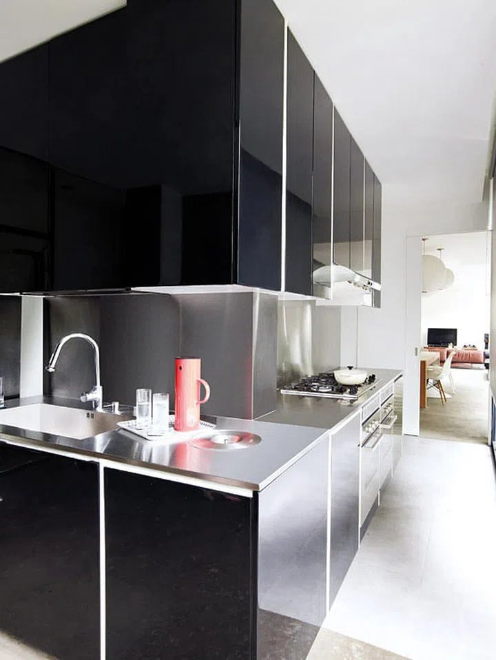 The stainless steel kitchen countertops and backsplash are easy to clean and maintain. The position of the stove was fixed due to geomancy reasons. Interior design by One Stop Concept.