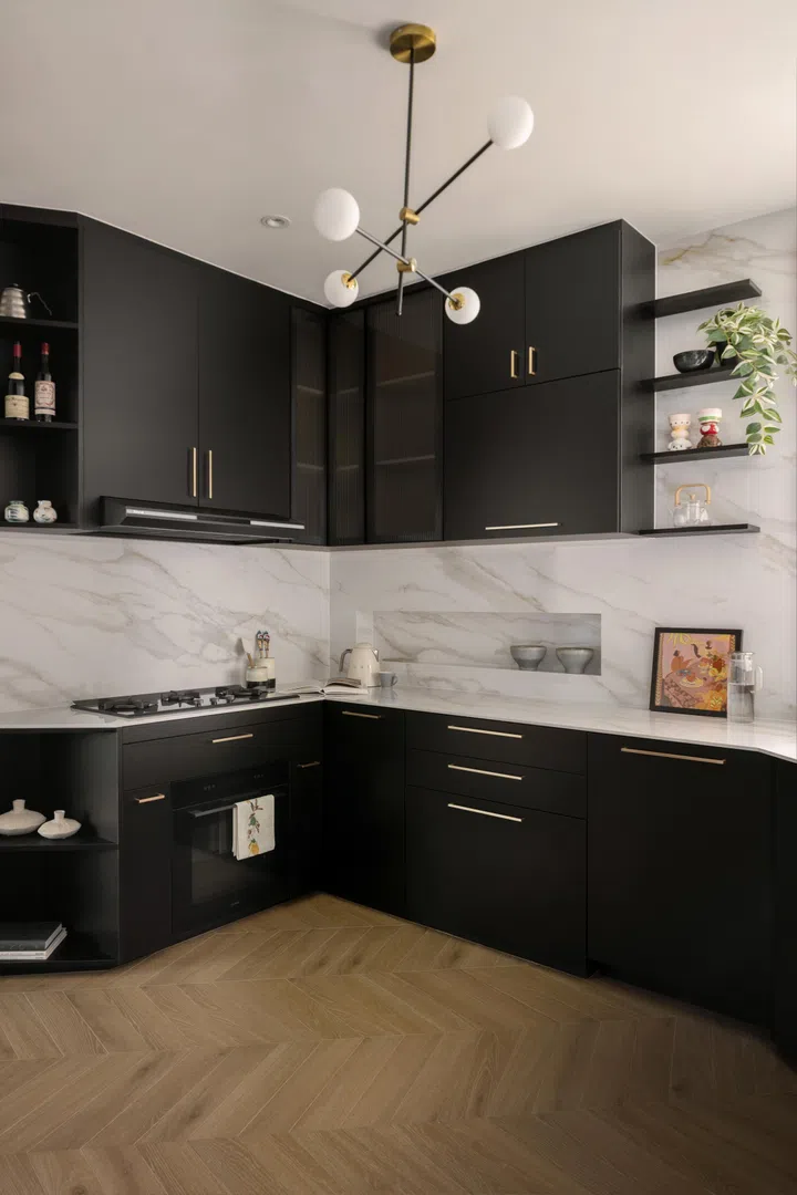 The kitchen comes in a classic black-and-white ensemble with brass hardware.