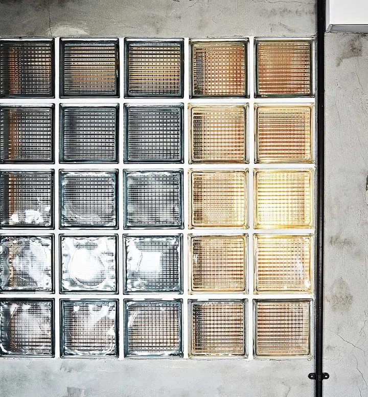 The glass block wall between the dining area and bathroom add a retro touch while allowing diffused light into the bathroom.