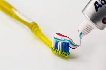 Close up of a toothbrush with toothpaste against a white background.