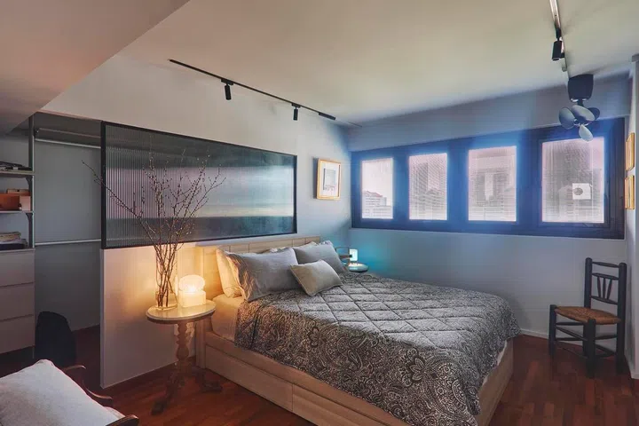 A fluted glass partition subtly separates the sleeping area from the walk-in wardrobe, allowing light to pass through while reinforcing the home’s blend of modern and old-school influences.