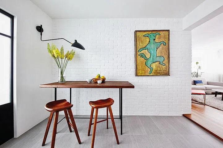 The raw wood table goes perfectly with the brick wall.