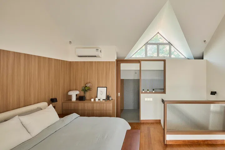 Set beneath a pitched roof, the attic bedroom is kept deliberately minimal to emphasise volume and calm.