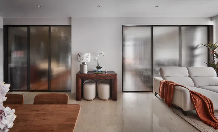 Frosted glass sliding doors create a visual boundary while still allowing natural light to brighten the living room.