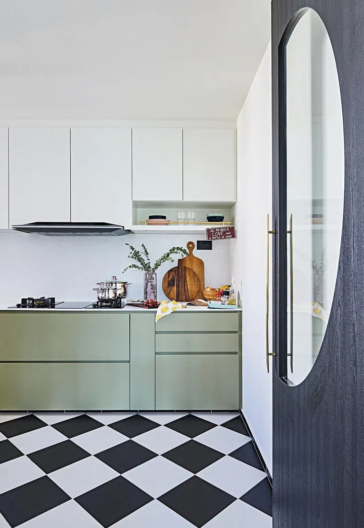 A door provides
the option of
closing off the
kitchen. The
semi-circle
window is a
creative solution
to aid the visual
flow between
the kitchen and
the living area.