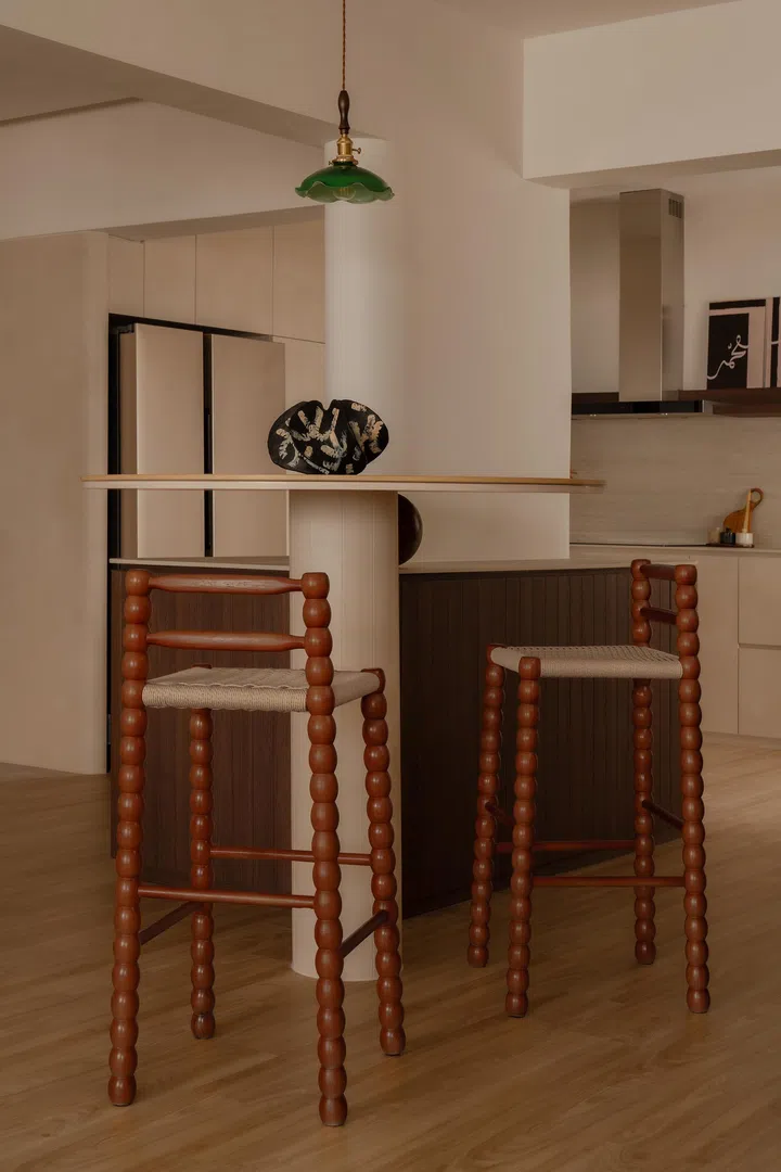 The round bar table connects directly to the island, with softened edges and custom detailing, paired with matching bar stools Yayu sourced from Taobao.