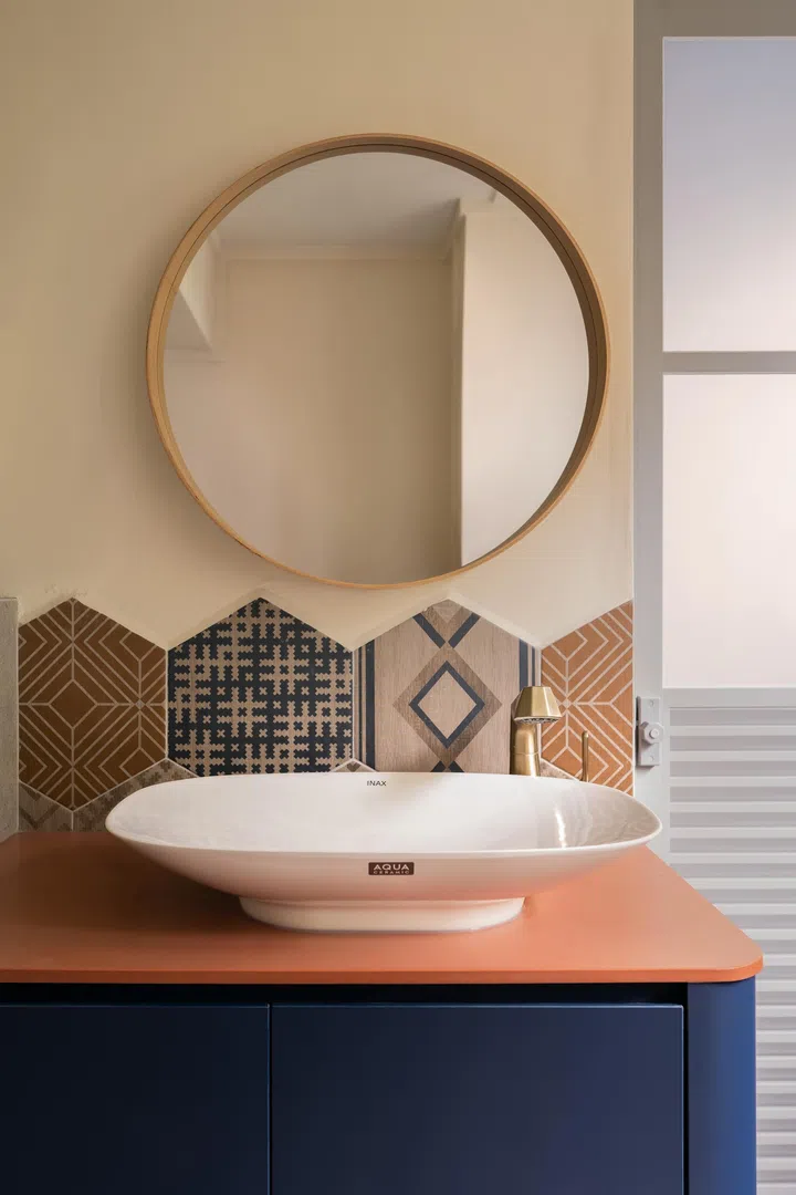 A sleek sink-and-mirror pairing completes the vibrant, layered look of the bathroom.