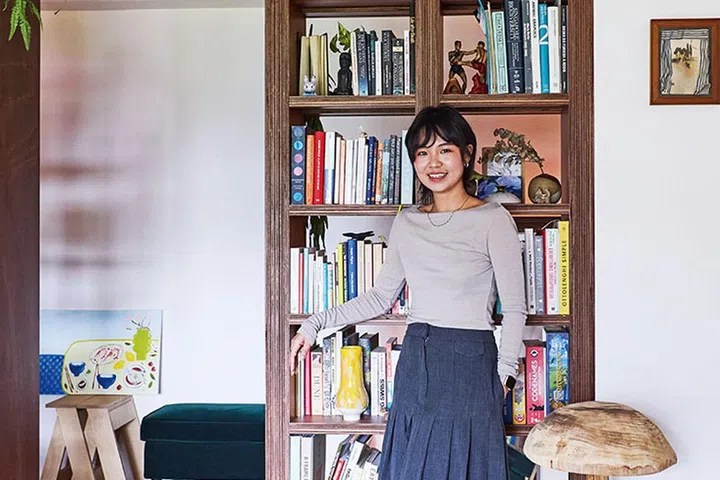 Natalie with the unique bookshelf she designed, which has come to be an icon of her home.