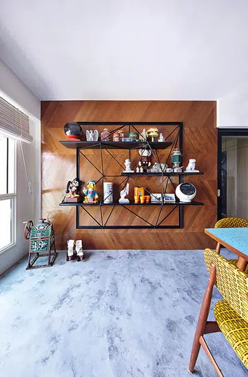 The design of the feature wall, with Indonesian teak pieces laid in a chevron pattern, is a "playful interpretation" of the shoe storage's faceted design. Interior design by Studio Super Safari
