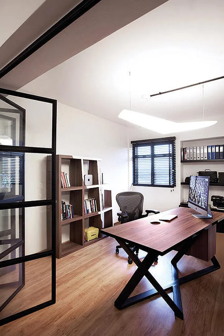 A glass accordion door offers the option of semi-privacy for this study, and it can also be folded up to merge the room with the rest of the home. (Interior design by Space Sense)