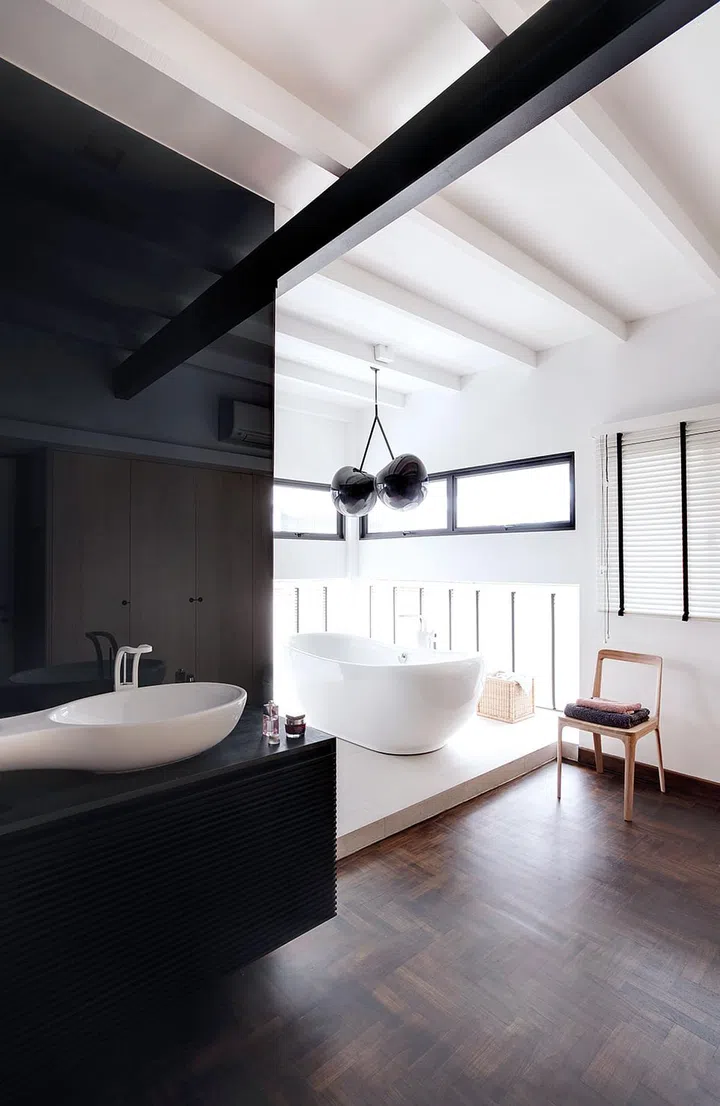 By cleverly zoning the space, this bath area remains cosy despite being part of an open-plan design concept. The homeowners are also fans of dramatic lighting pieces, and chose this eccentric cherry-shaped pendant lamp, bought online from a Slovakian designer, to anchor this space.