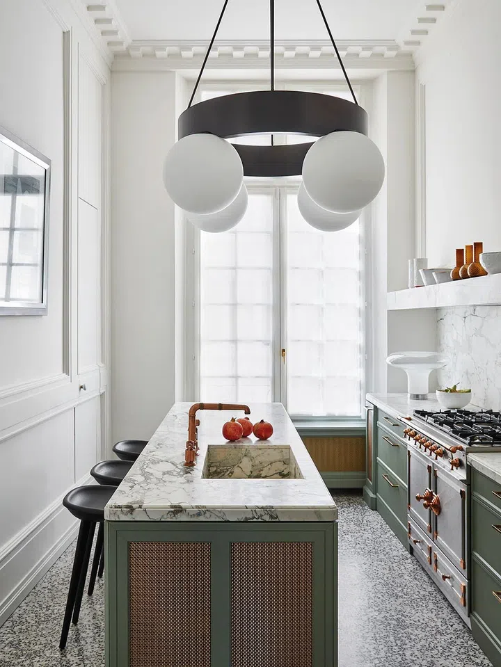 Kitchen incorporating thicker marble slabs, and fixtures in matte metallic finish.