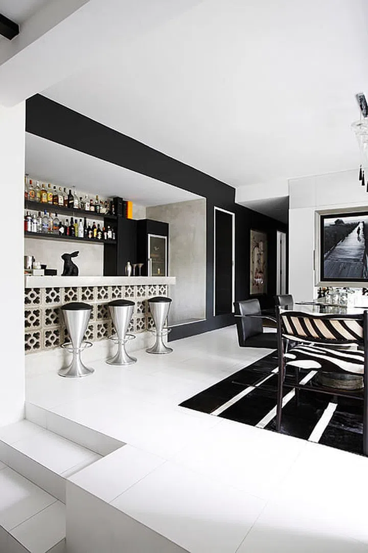 A protruding floor beam between the dining room and a smaller space that had been hacked open became the base for the bar, which Andrea built using ventilation blocks.