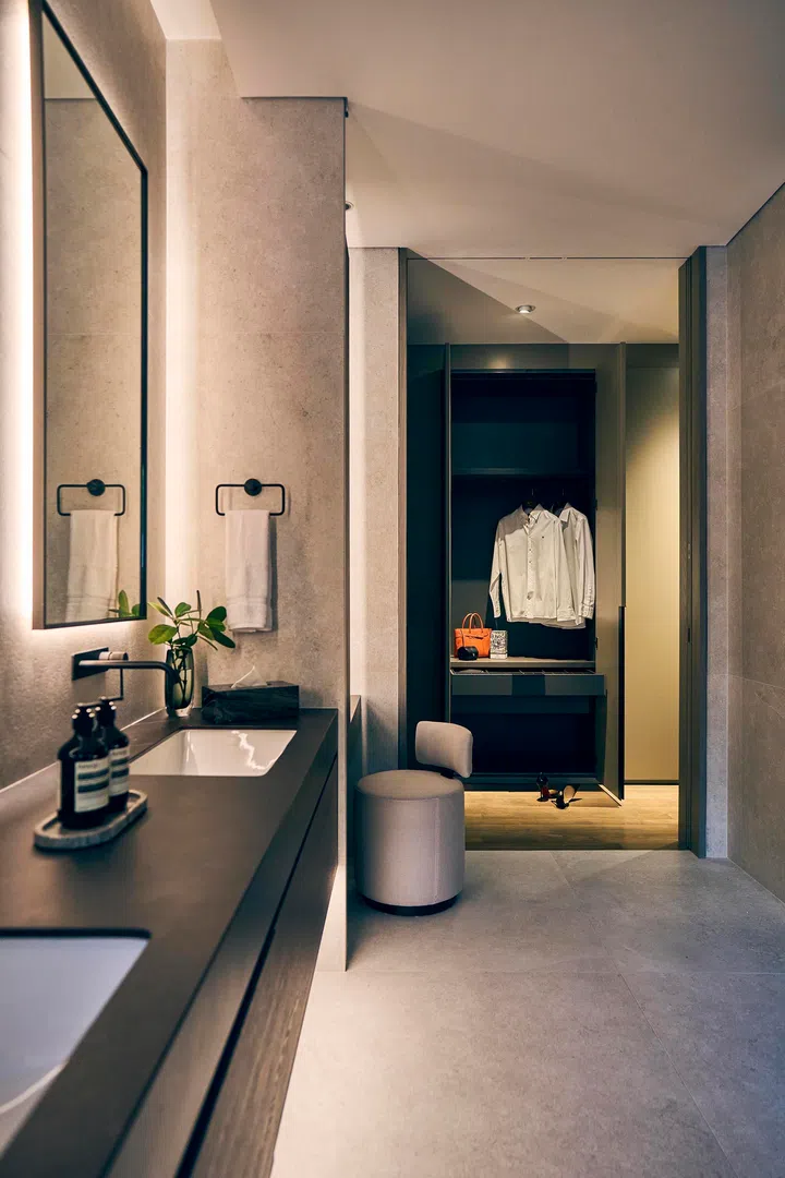  The bathroom flows into the wardrobe, a transitional zone where dressing and grooming merge seamlessly.

