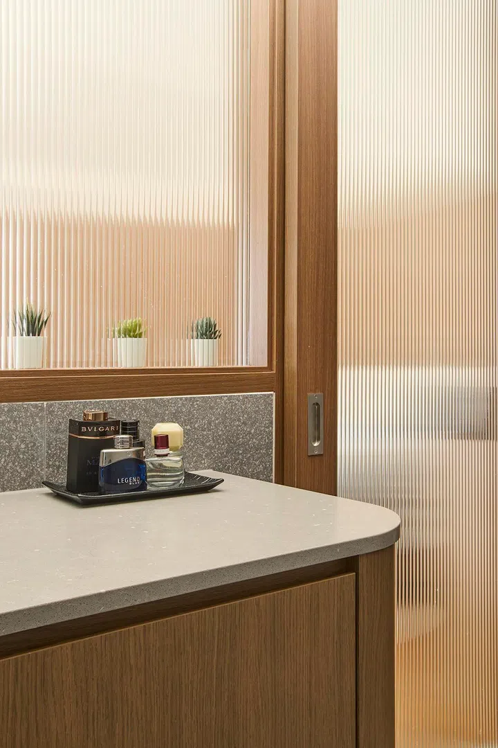 Fluted glass panels filter light while maintaining privacy between zones.