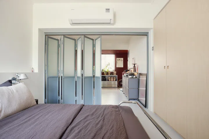 A custom accordion door, made by the same craftsman behind the steel entrance gate, separates the living room from the bedroom.