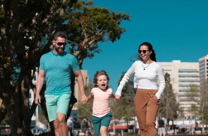 Young couple walk in city park with son. Happy family walking the city street, casual lifestyle. Photo 123RF
