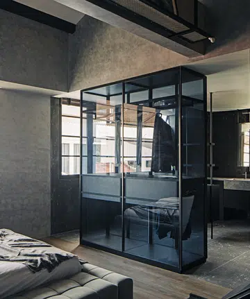 A glass wardrobe in a walk-up apartment becomes a feature and dividing wall between the bedroom and bathroom.
