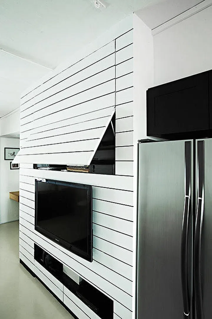 Push-open compartments concealed within the television feature wall.