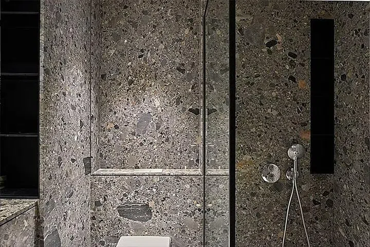 Credit: The guest bathroom walls are clad with Gris Urbaine stone. (Photo: Wynk Collaborative)
